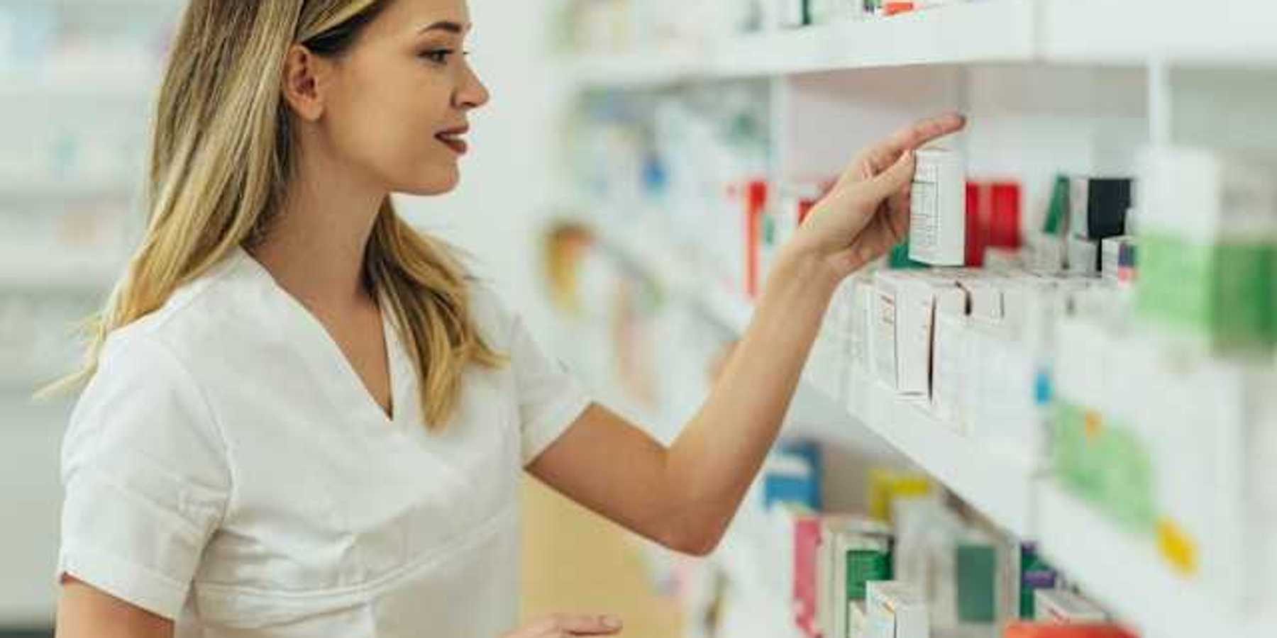 A pharmacist looking at products on a shelf