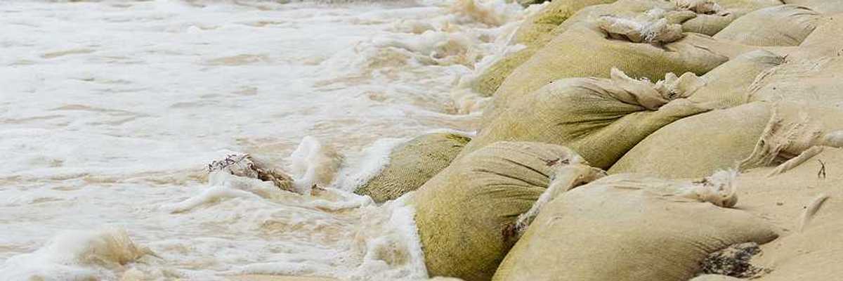 A pile of sandbags helping to keep waves from flooding the beach