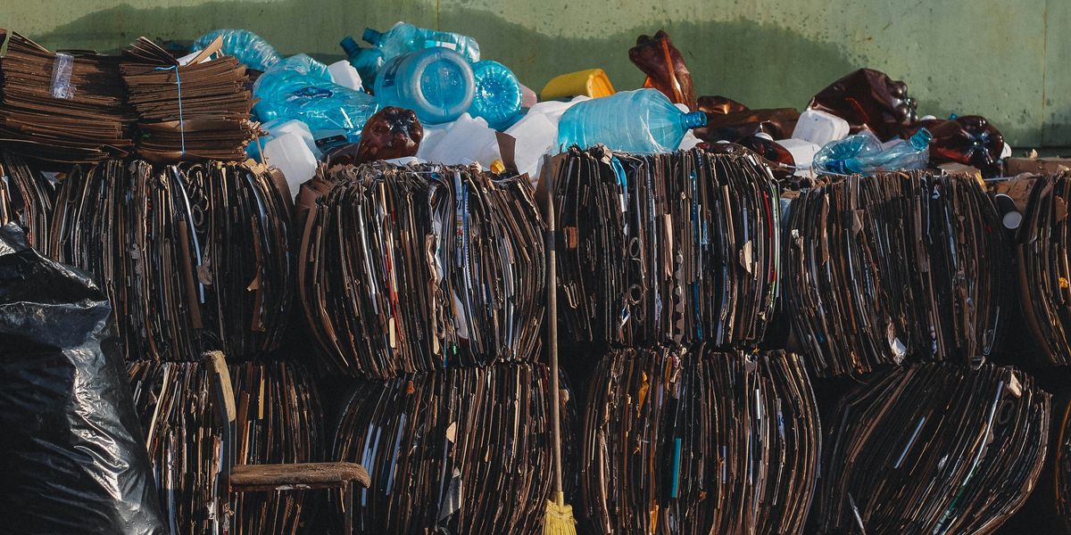 a pile of trash bundles sitting next to a green wall.