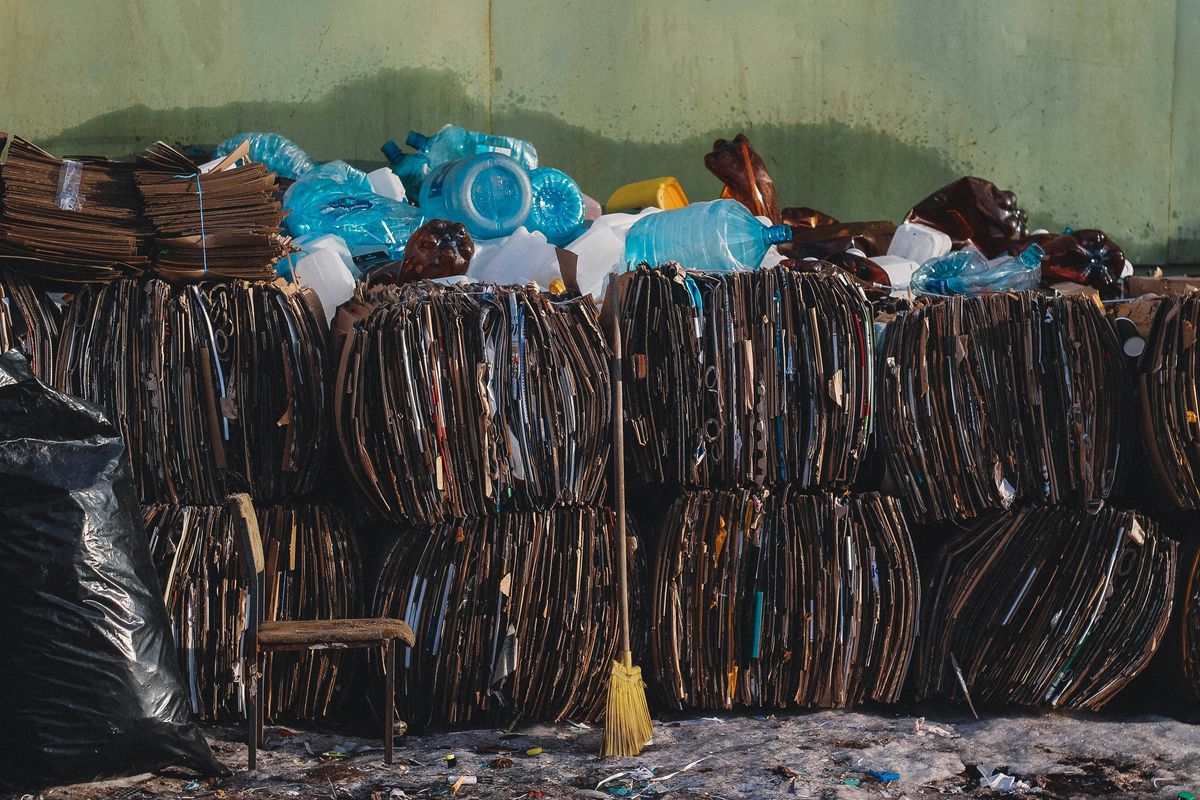 a pile of trash bundles sitting next to a green wall.