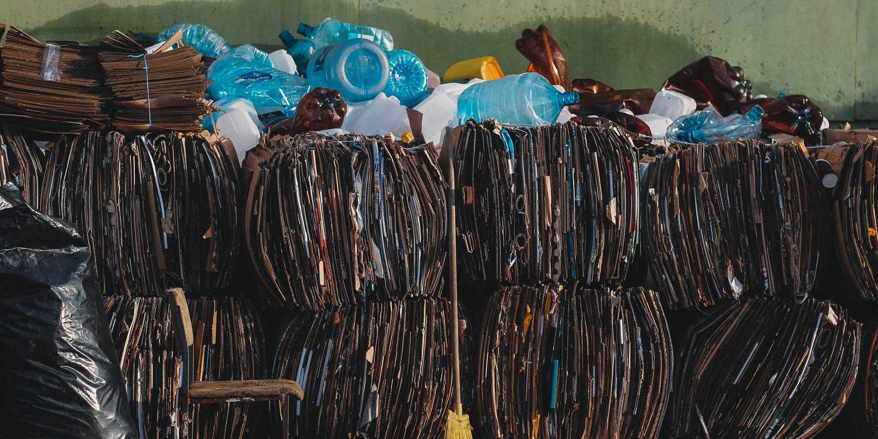 a pile of trash bundles sitting next to a green wall.