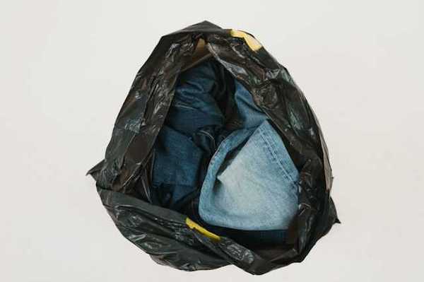 A plastic bag filled with old denim jeans