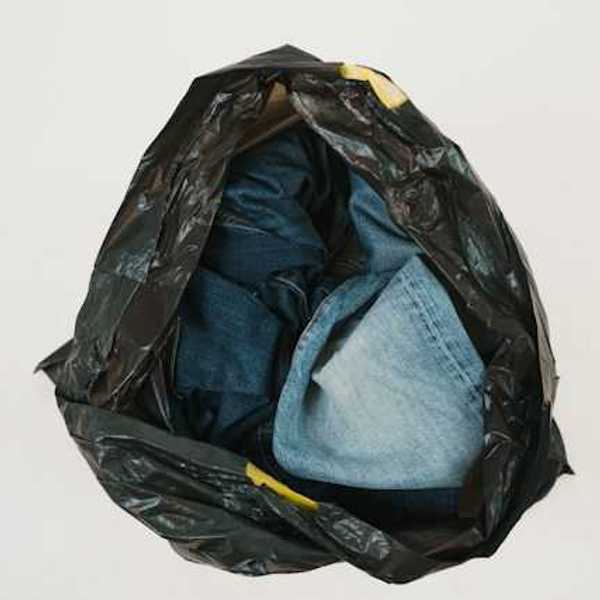 A plastic bag filled with old denim jeans