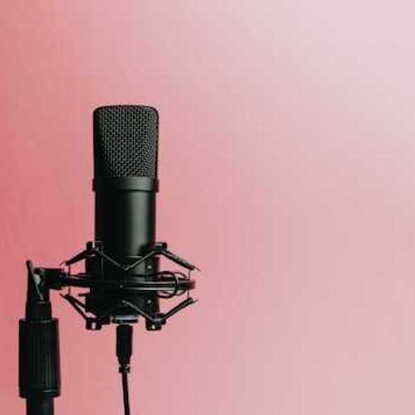 A podcast microphone against a pink background