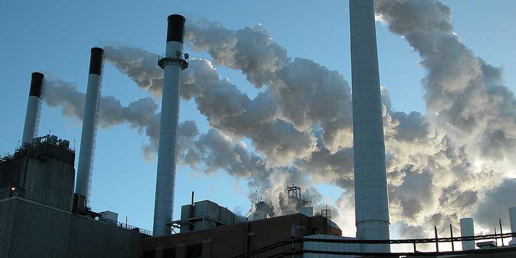 A power plant's smokestacks billowing smoke into the air