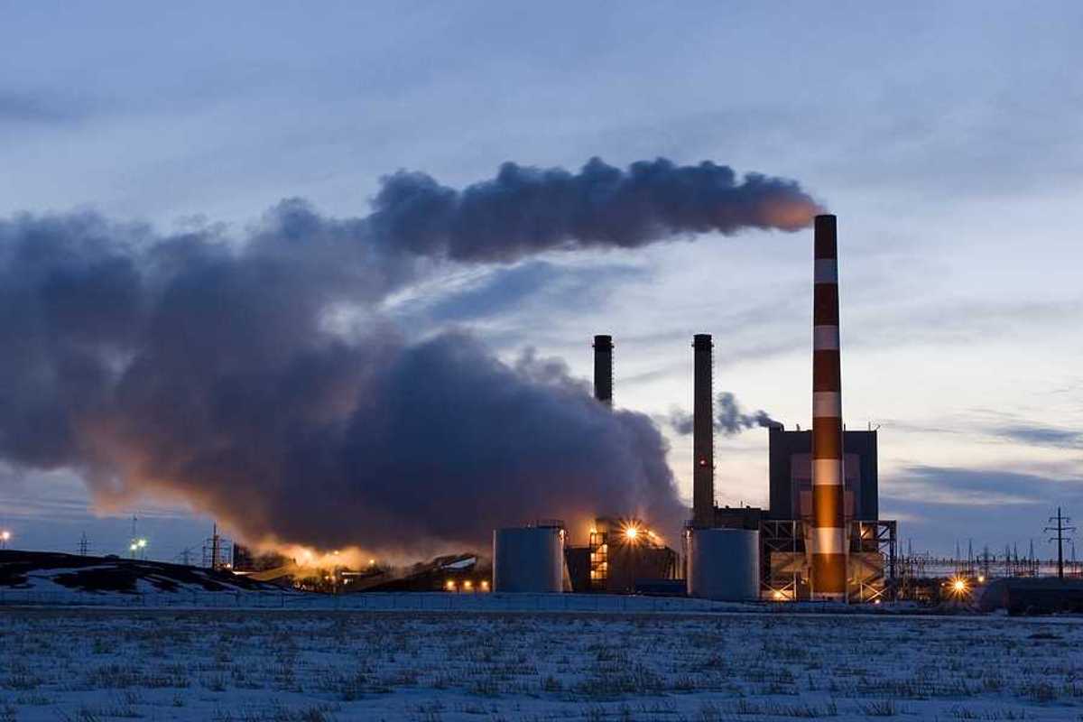 A power plant with smoke emitting from the smokestacks