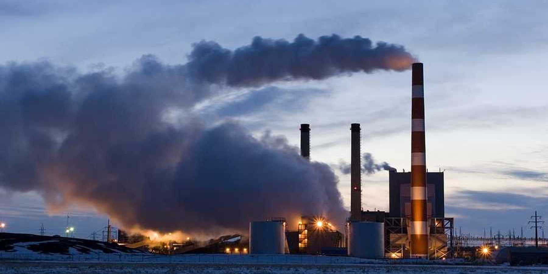 A power plant with smoke emitting from the smokestacks