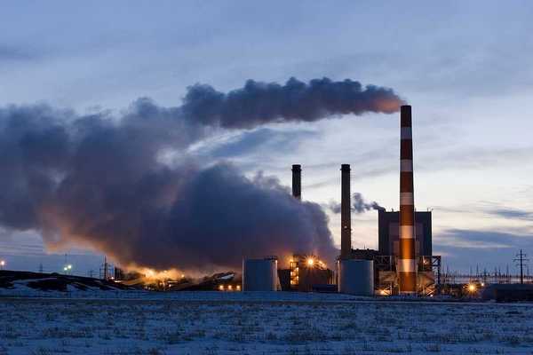 A power plant with smoke emitting from the smokestacks