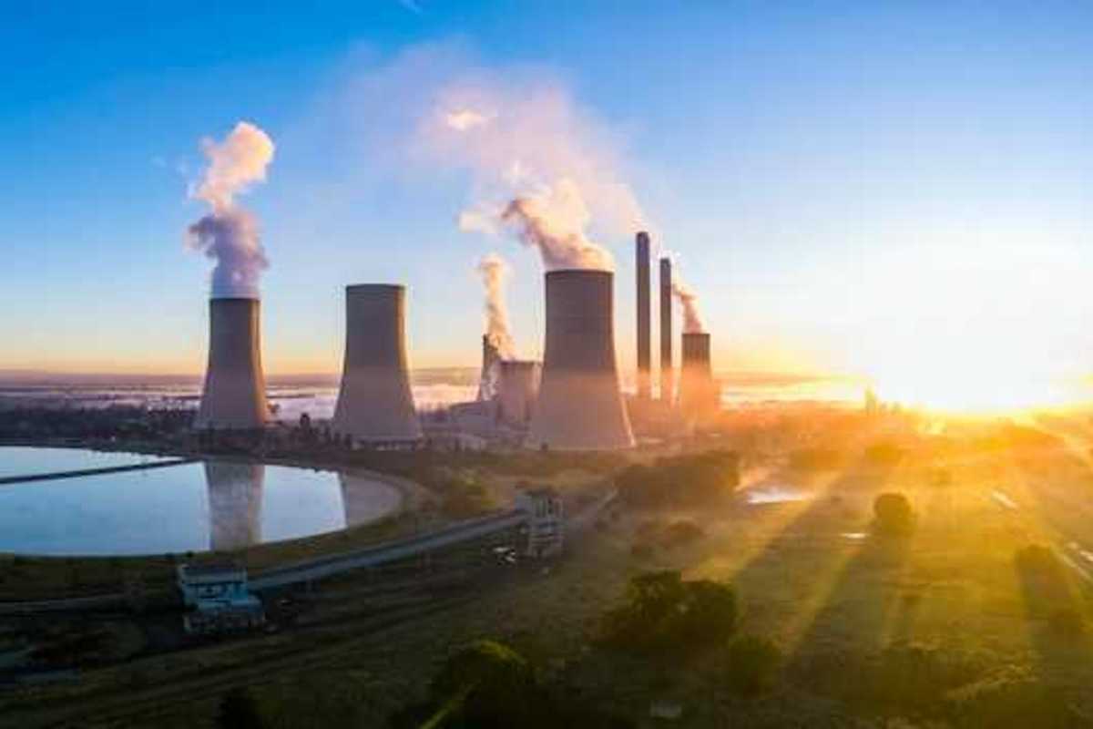 A power station with cooling towers seen at sunrise