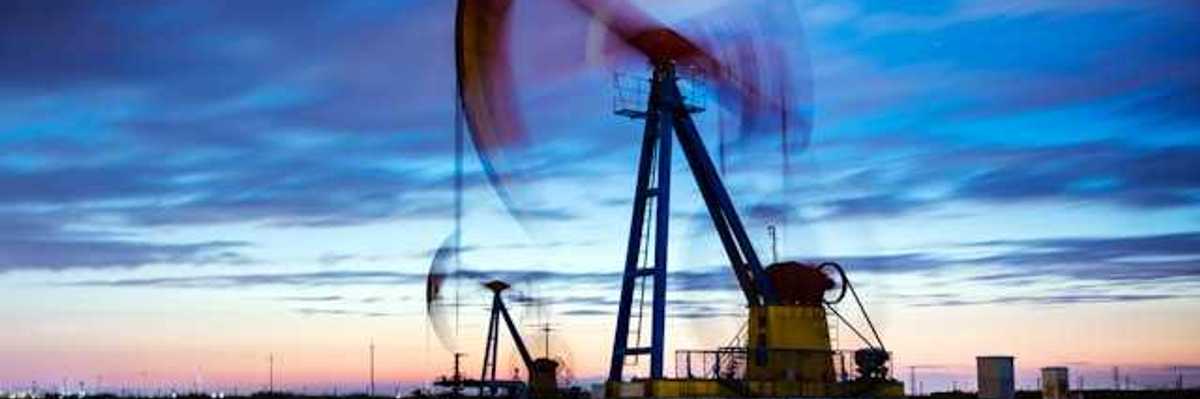 A pump jack against a sunset