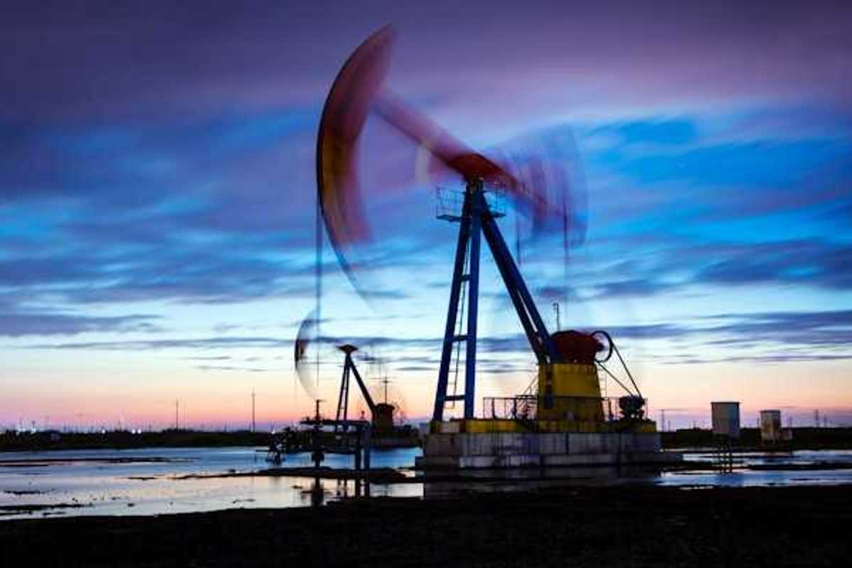 A pump jack against a sunset