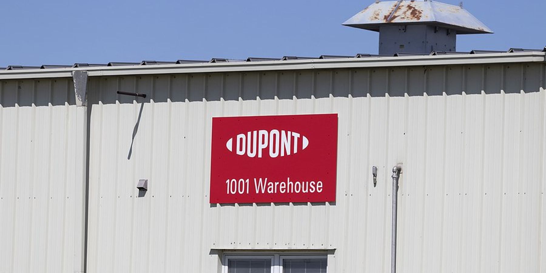 A red and white sign with the words Dupont and 1001 Warehouse on the side of a building.