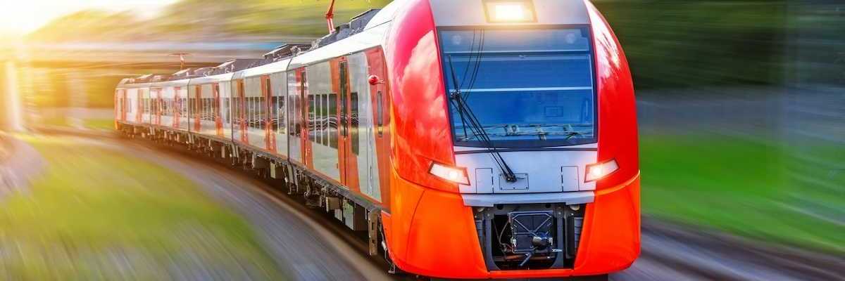 A red, high-speed passenger train hurtling down the tracks