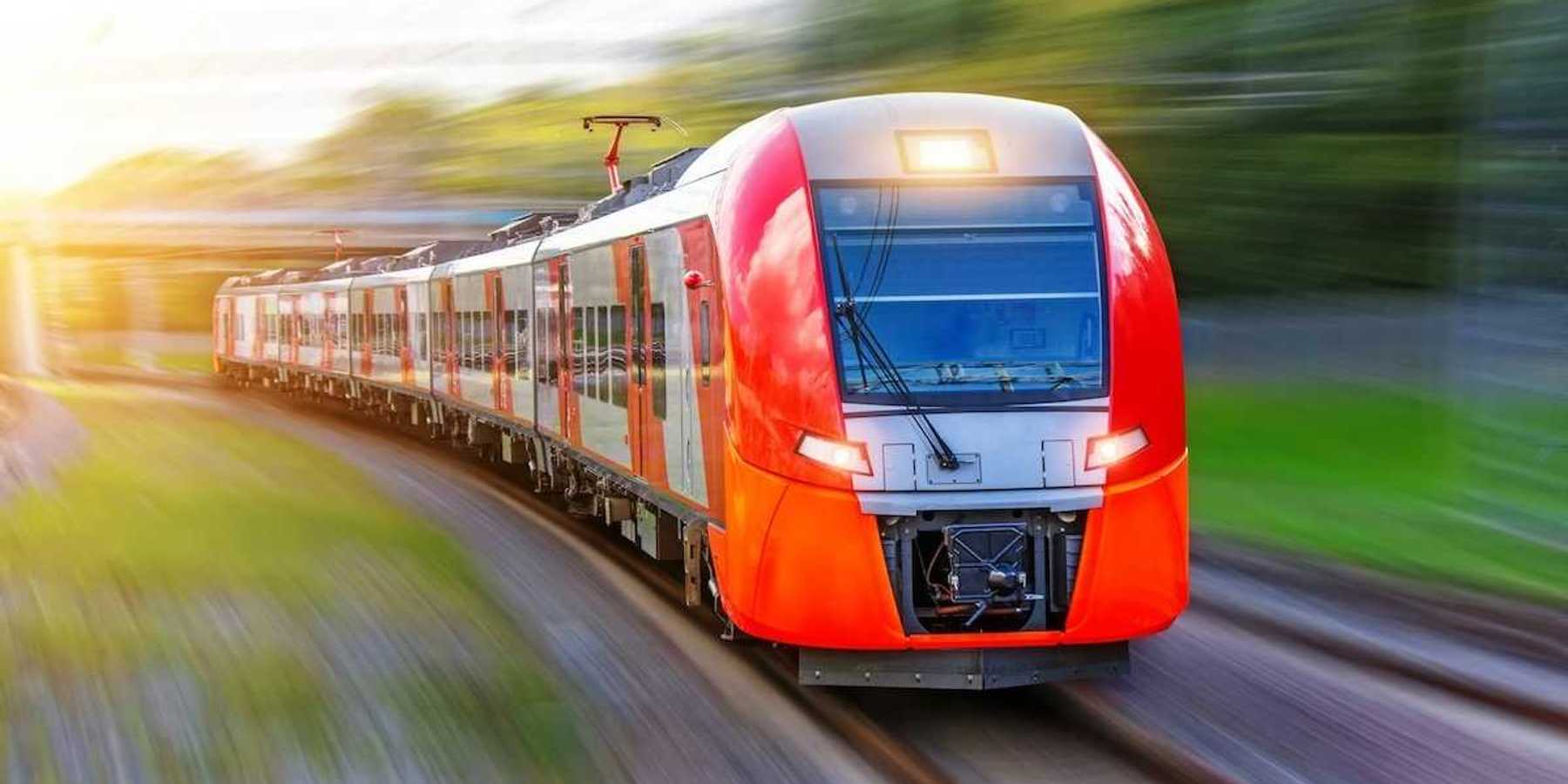 A red, high-speed passenger train hurtling down the tracks