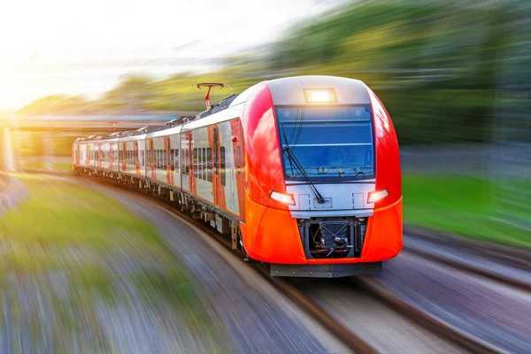 A red, high-speed passenger train hurtling down the tracks