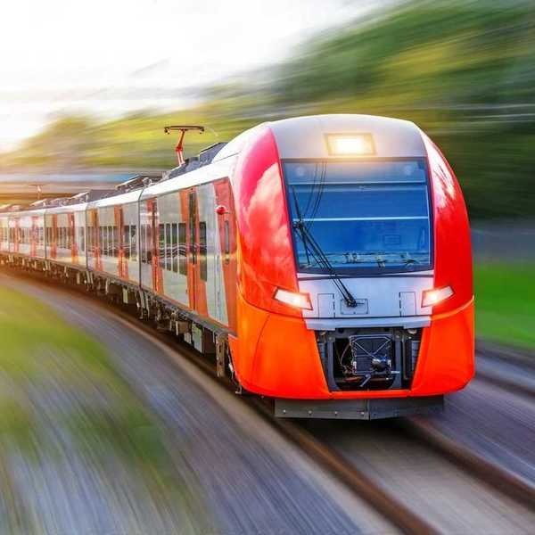 A red, high-speed passenger train hurtling down the tracks