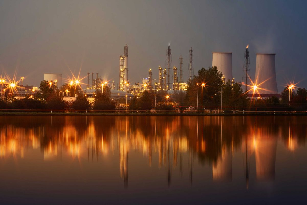 A refinery at night in front of a water source