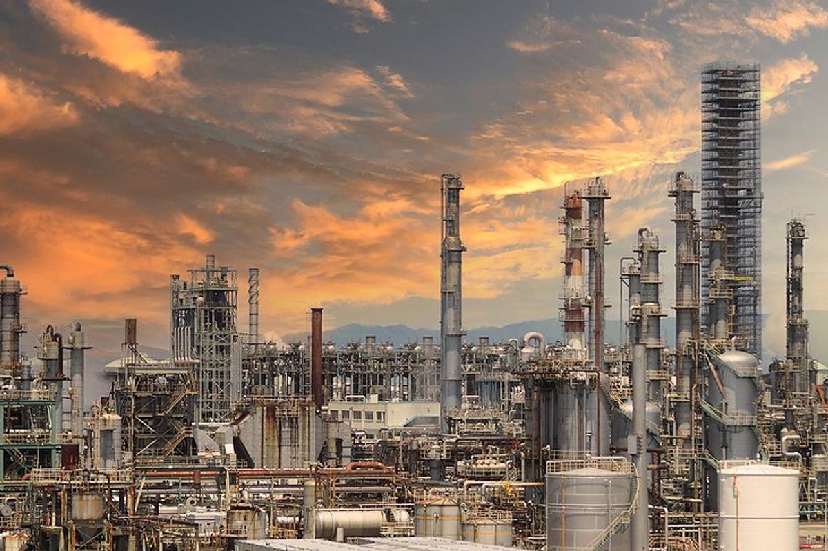A refinery under a pink, cloud-strewn sky.