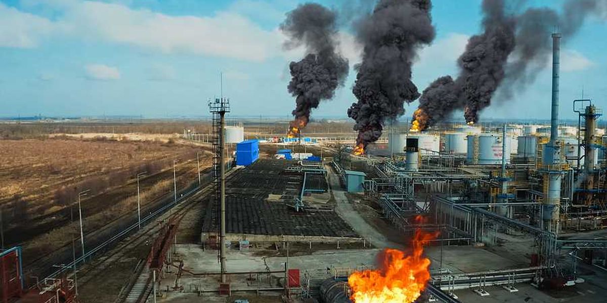 A refinery with flames and smoke emerging from equipment