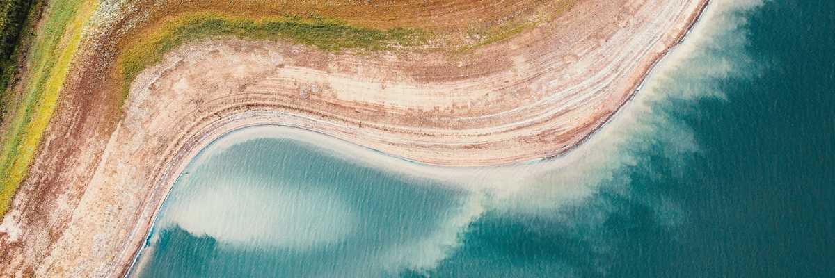 A reservoir viewed from above with dry shores