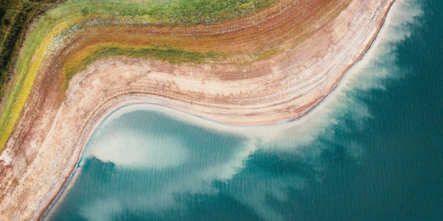 A reservoir viewed from above with dry shores