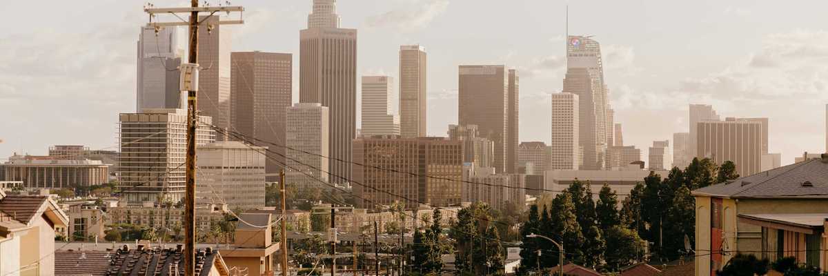 A residential street with Los Angeles skyscrapers in background.