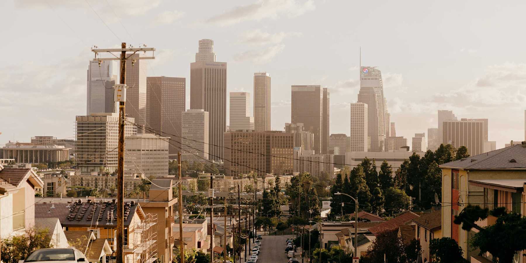 A residential street with Los Angeles skyscrapers in background.
