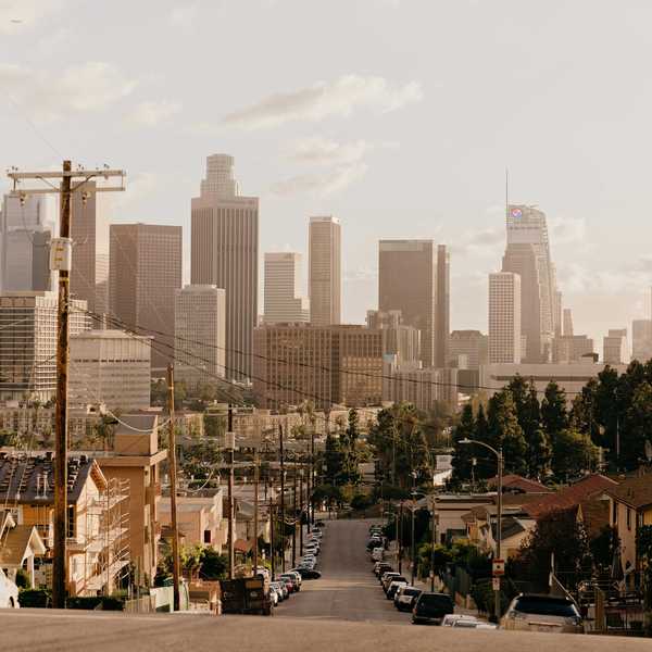 A residential street with Los Angeles skyscrapers in background.