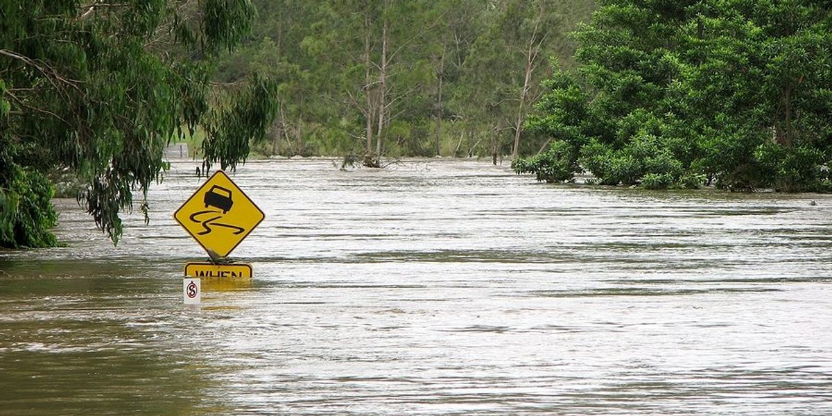 A road sign covered by rising flood waters.