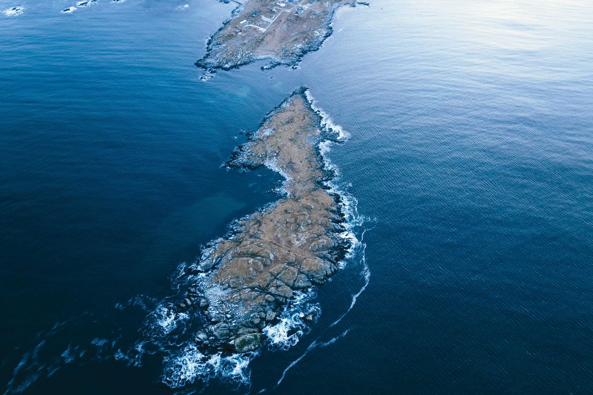 A rocky island in the middle of the ocean viewed from above