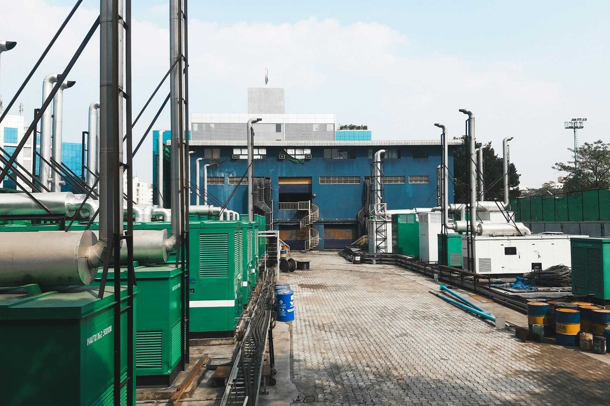 A row of diesel-powered generators outside of an industrial building
