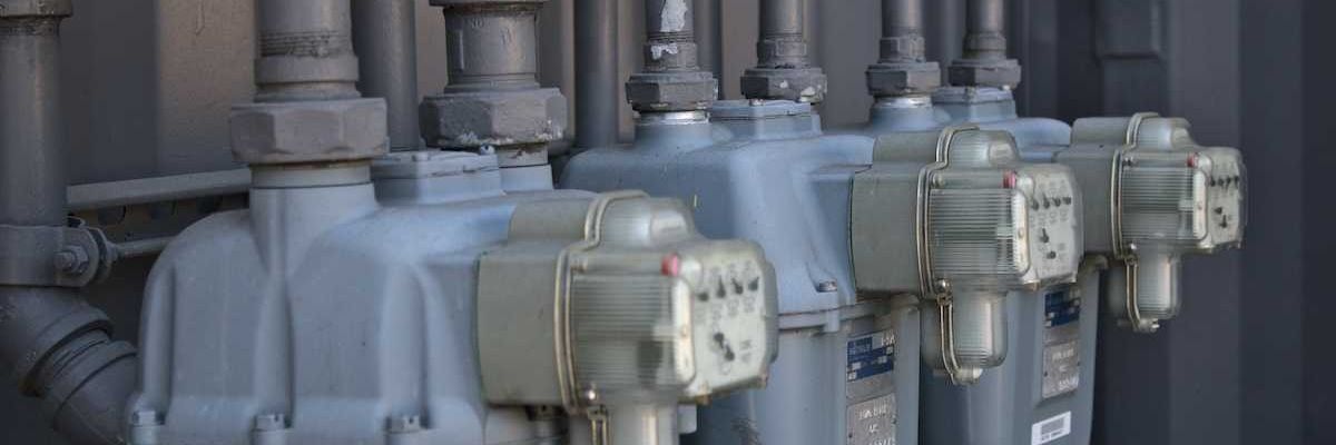 A row of gas meters mounted on outside of building