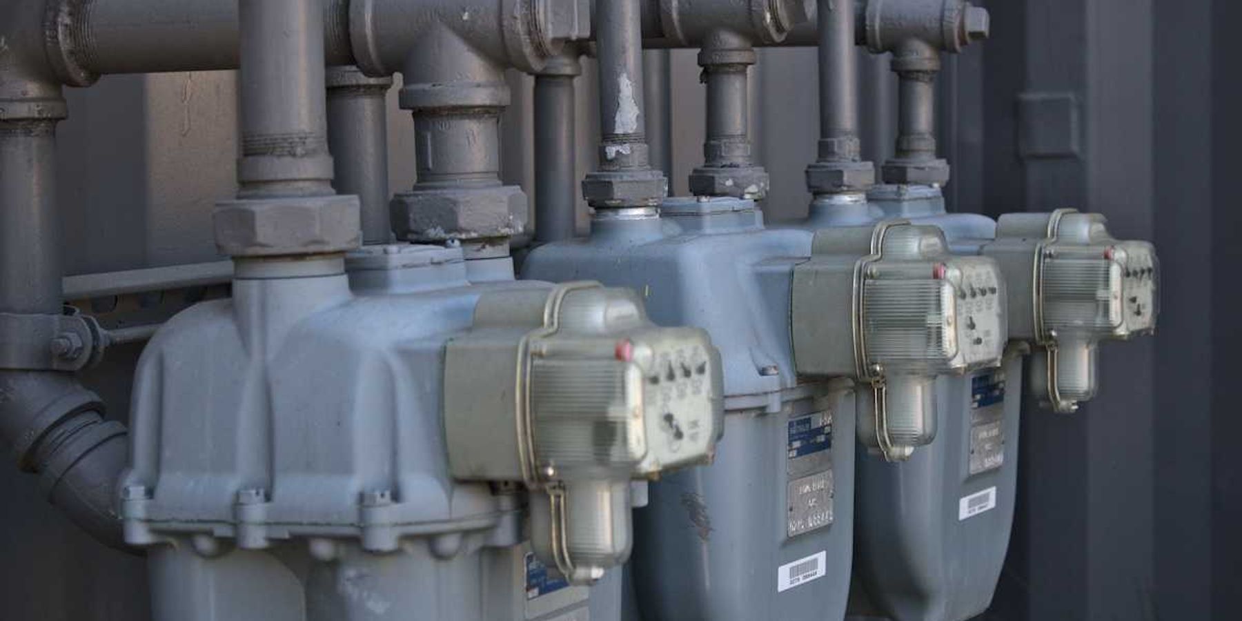 A row of gas meters mounted on outside of building