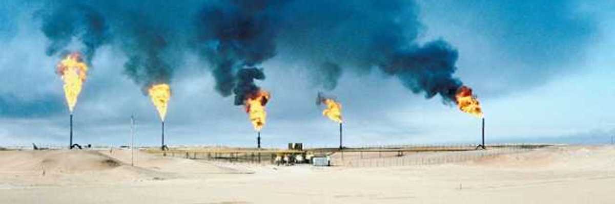 A row of gas towers flaring smoke and fire into the air