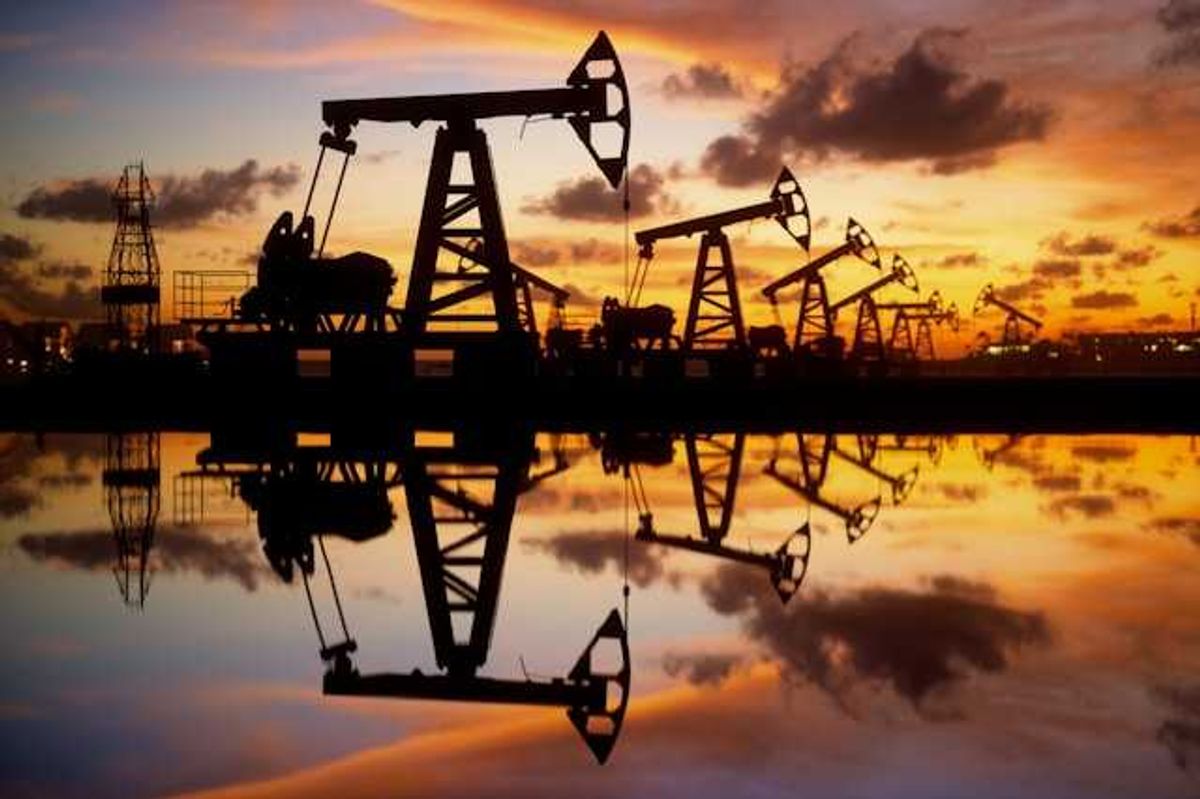 A row of oil pump jacks at sunset