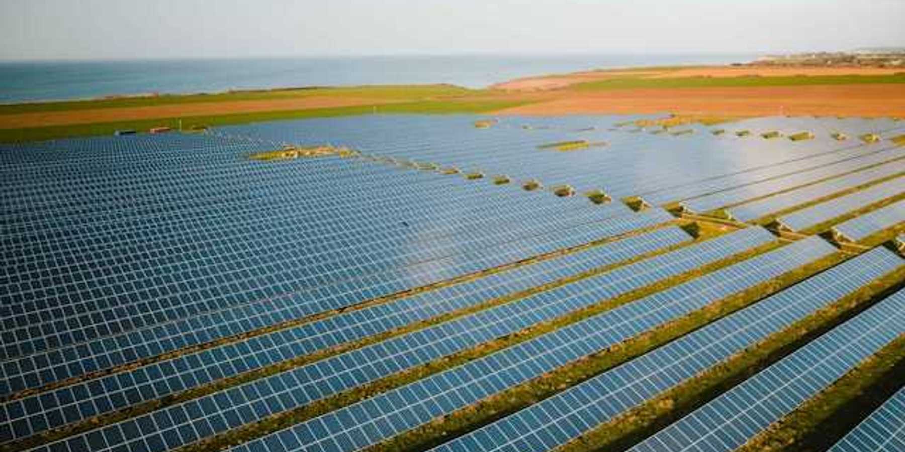A row of solar panels atop green fields