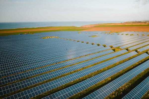 A row of solar panels atop green fields