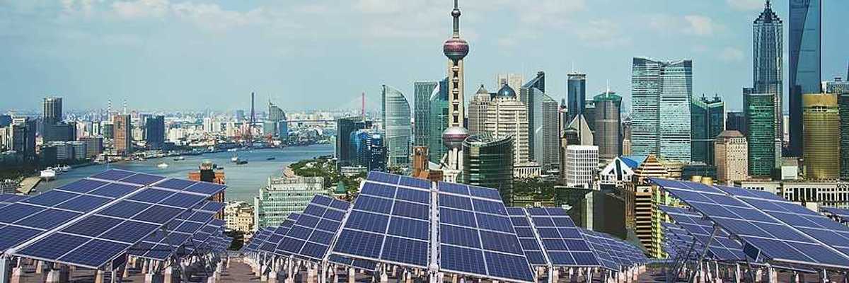 A row of solar panels with the city of Shanghai in the background