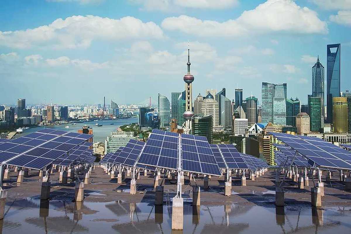 A row of solar panels with the city of Shanghai in the background