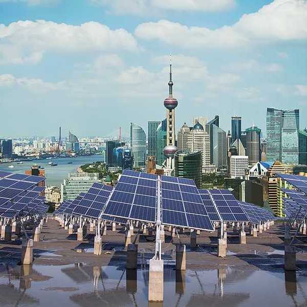 A row of solar panels with the city of Shanghai in the background