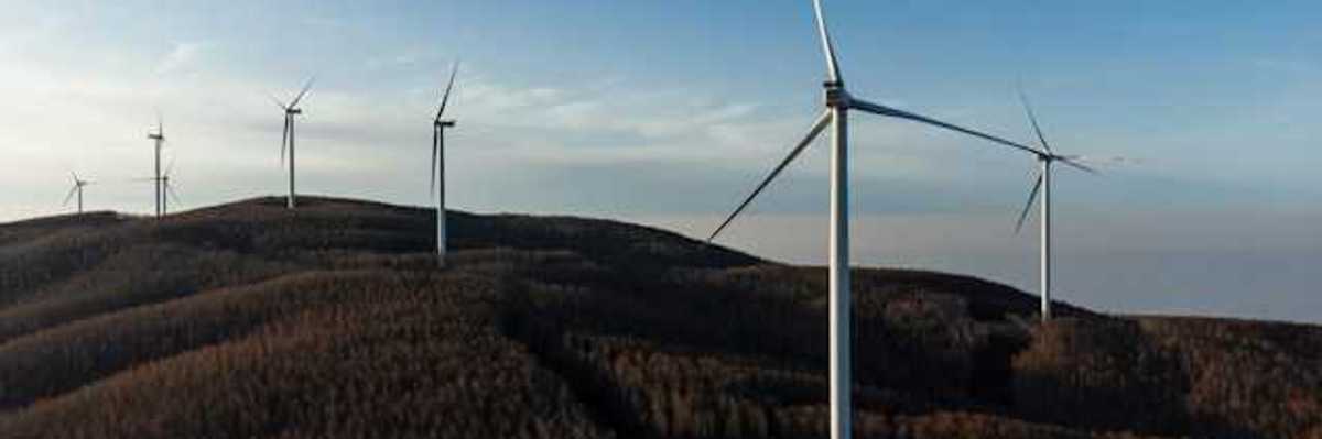 A row of wind energy turbines along the ridge of a mountain