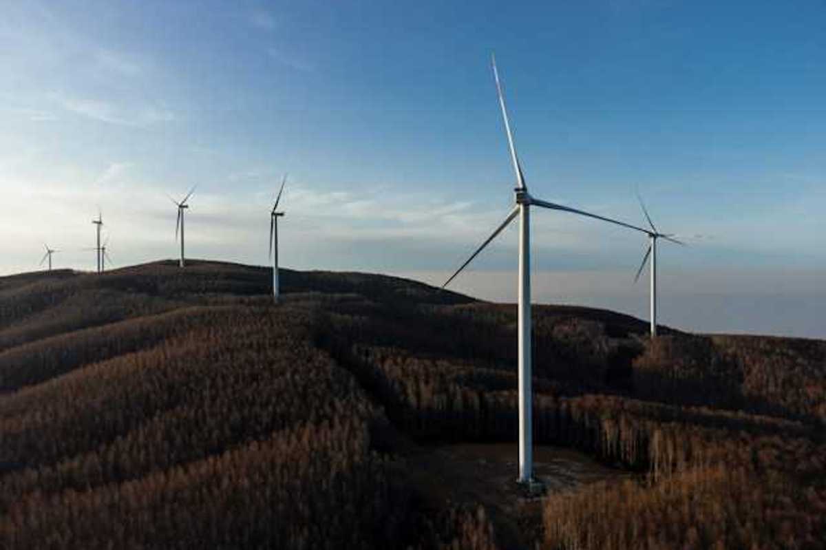 A row of wind energy turbines along the ridge of a mountain