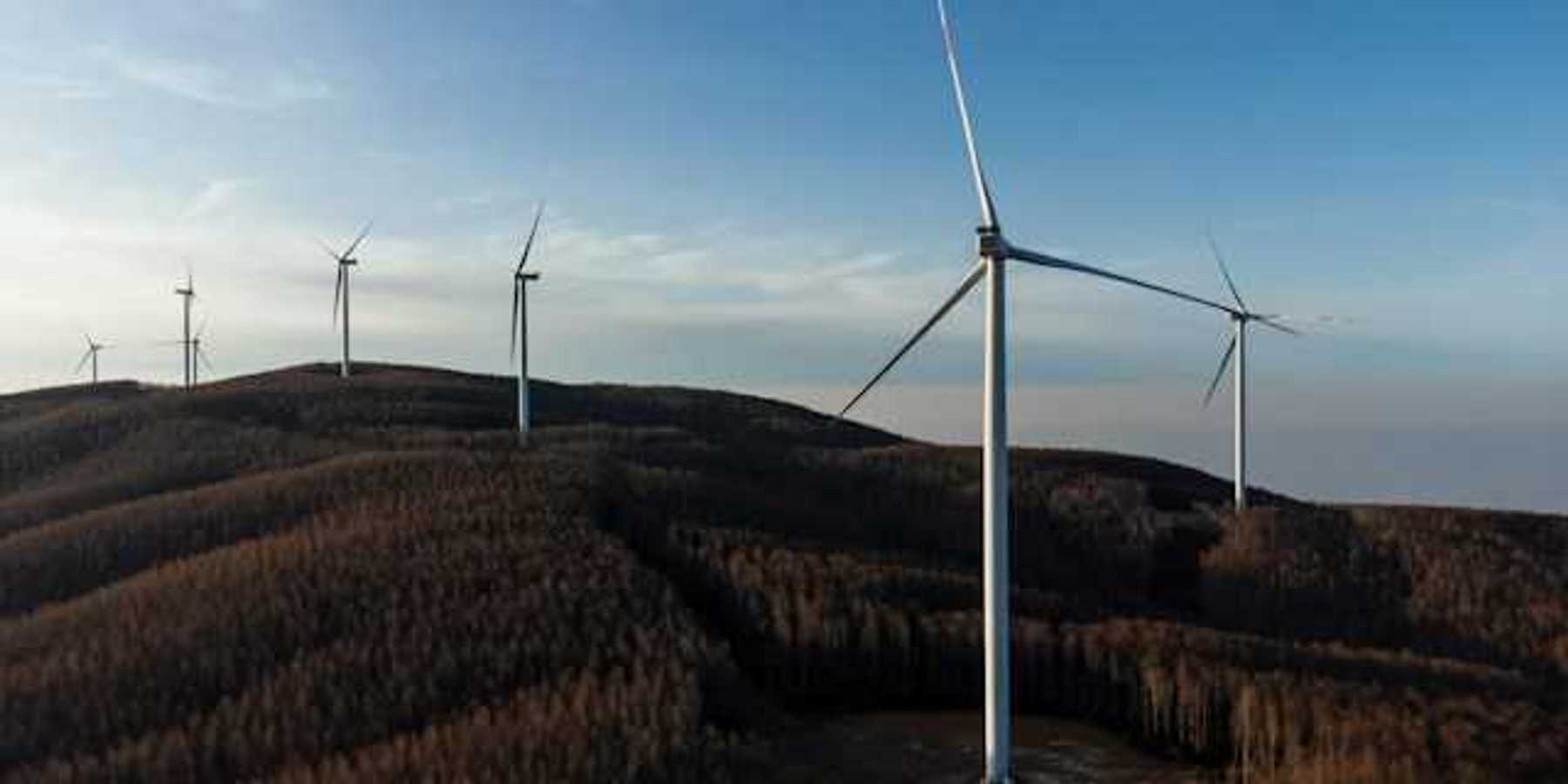 A row of wind energy turbines along the ridge of a mountain