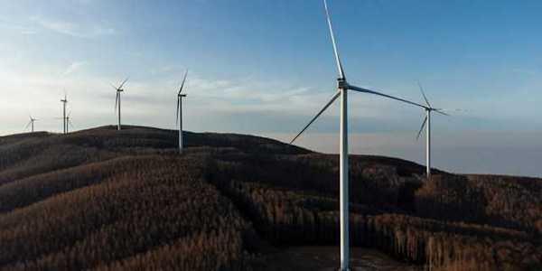 A row of wind energy turbines along the ridge of a mountain