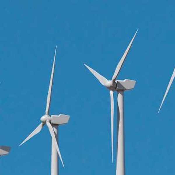 A row of wind turbines against a blue sky
