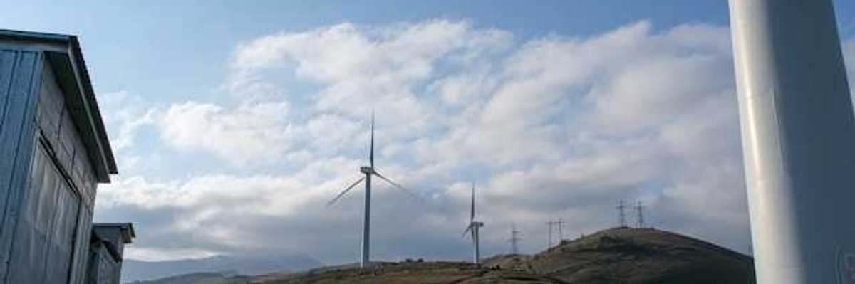 A row of wind turbines on dry hills