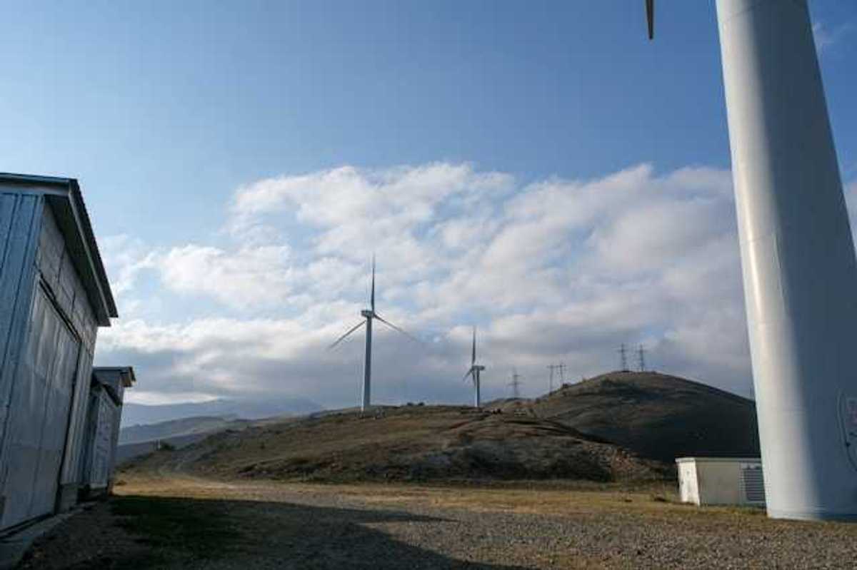 A row of wind turbines on dry hills