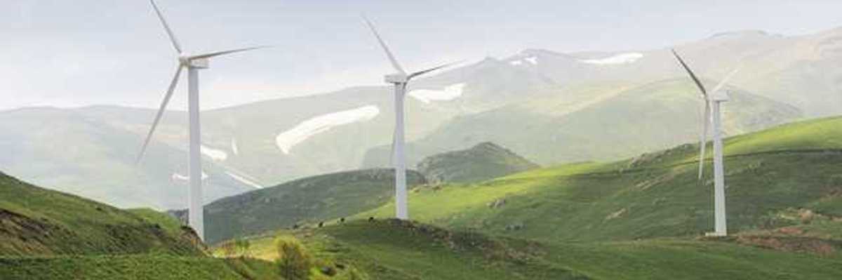 A row of wind turbines on green hills