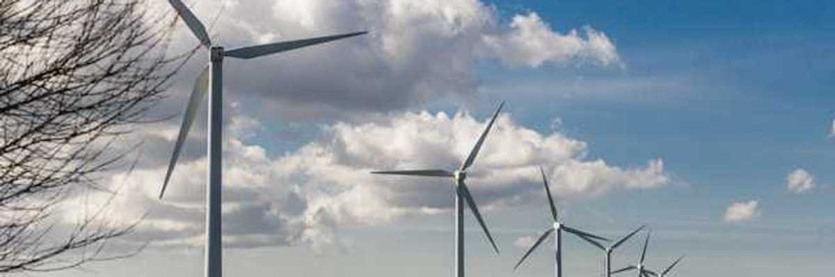 A row of wind turbines stretching into the distance