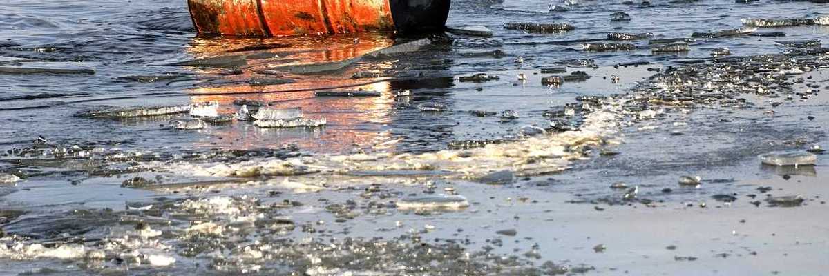 A rusty oil barrel floating in icy water